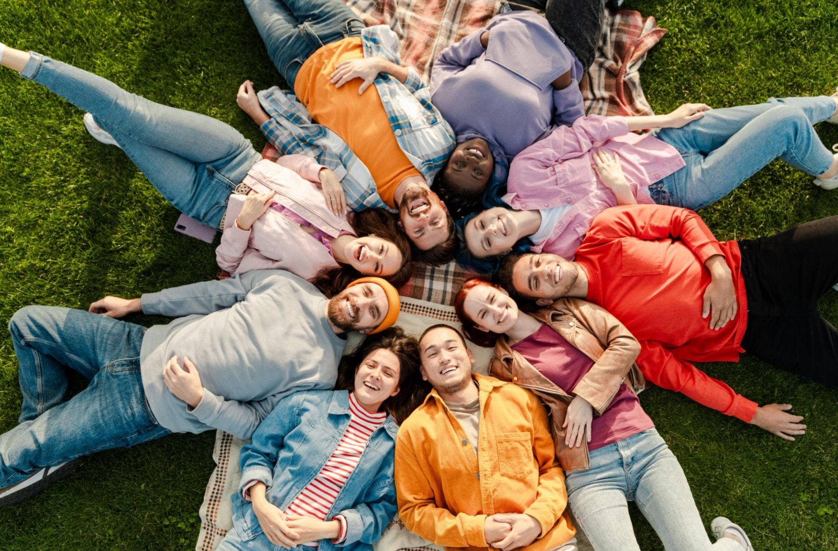 Diverse friends in a circle on grass — unity and connection — Embrace Forever